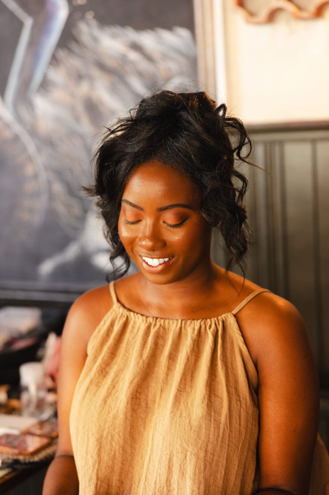 Bride smiling with eyes closed after hair and makeup by Brides by Aina during Black Romance London editorial at Prince of Peckham