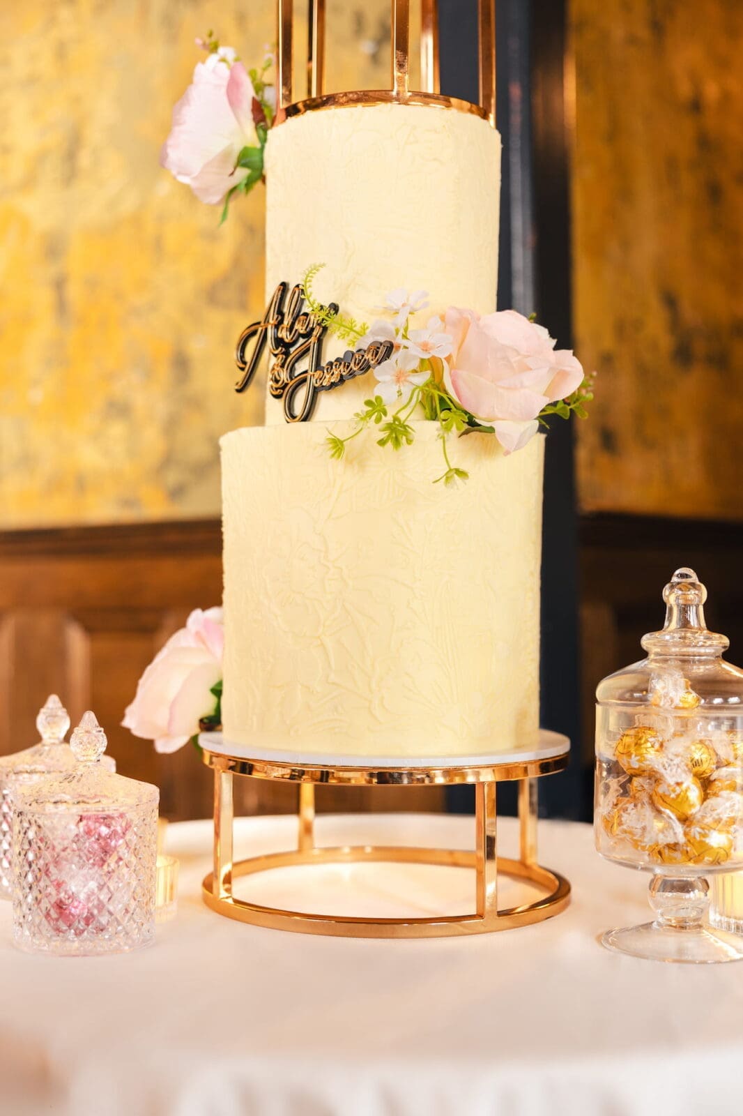 Ivory wedding cake with blush florals on gold stand by Wee Cupcakes during Black Romance London editorial at Prince of Peckham