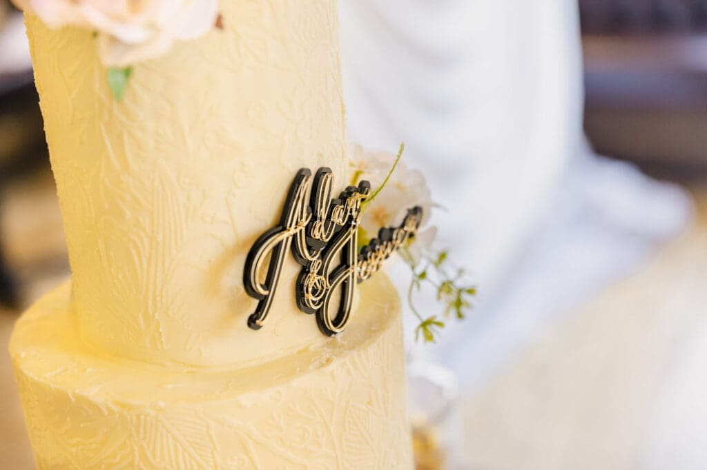 Ivory wedding cake close up with gold topper during Black Romance London editorial at Prince of Peckham