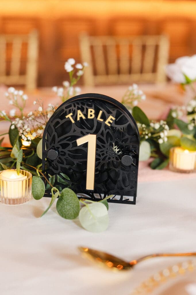 Black acrylic table number with gold typography by Recreate during Black Romance London editorial at Prince of Peckham