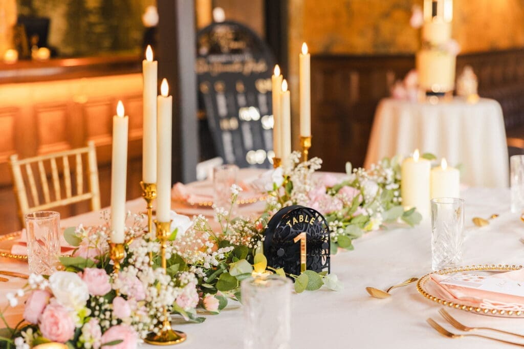 Gold candlesticks and blush floral tablescape with acrylic table number during Black Romance London editorial at Prince of Peckham