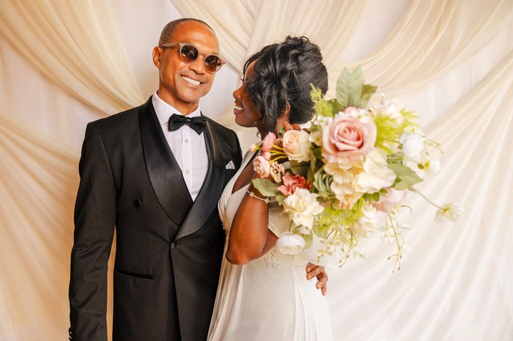 Black couple sharing an intimate moment with bridal bouquet during Black Romance London editorial at Prince of Peckham