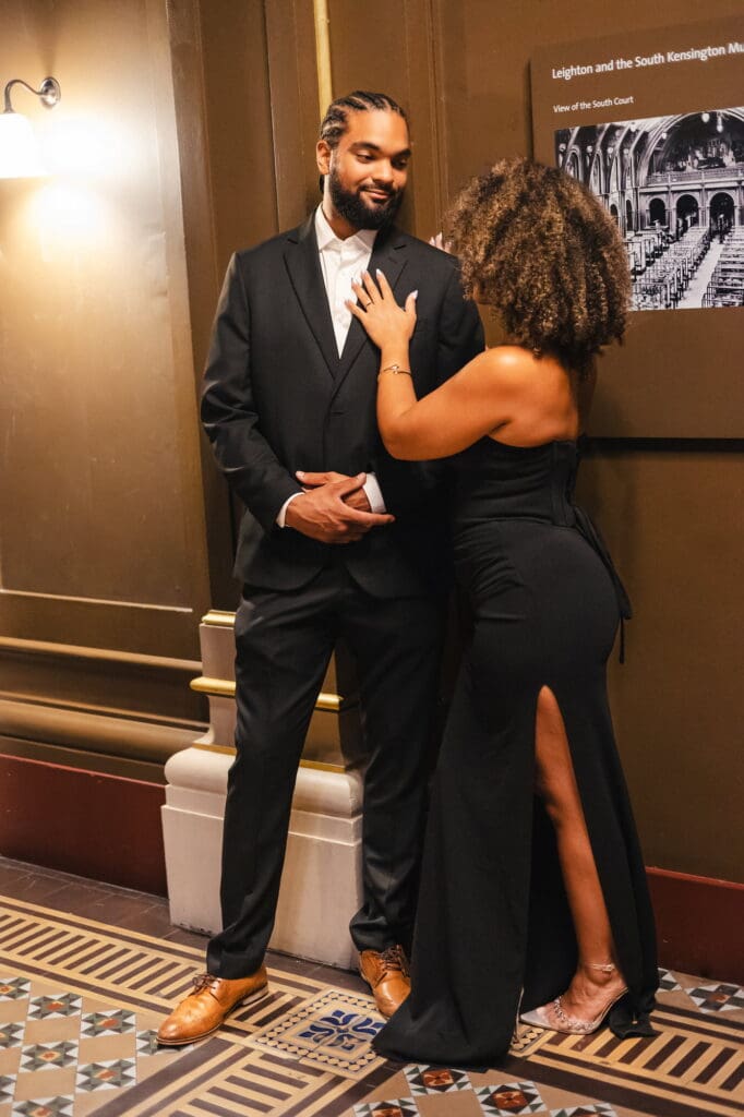 Couple posing in black attire at the Victoria and Albert museum in London for engagement shoot