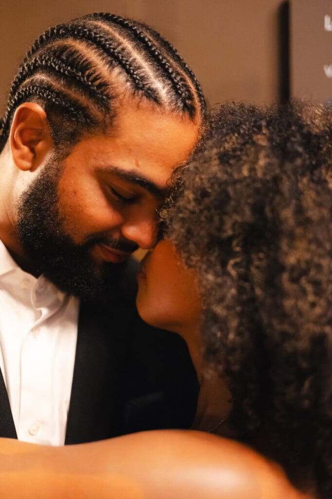 Couple embracing each other at the Victoria & Albert Museum for their engagement shoot in London.