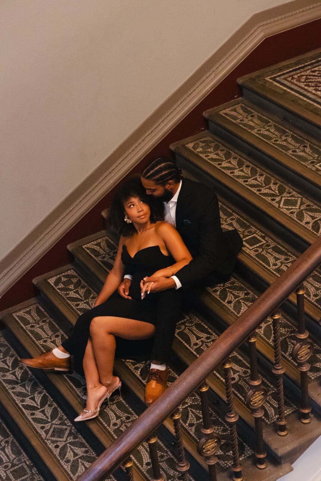 Couple seated together on patterned staircase inside the V&A Museum in London