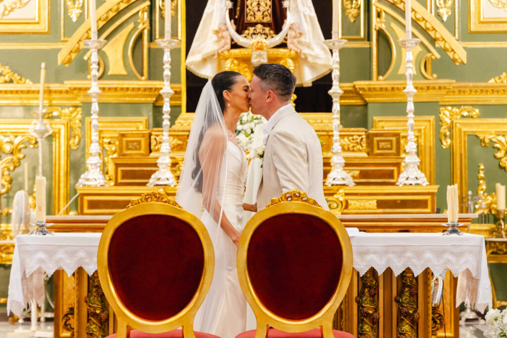 Anna and Michael share their first kiss during their wedding ceremony at Iglesia de la Encarnación in Marbella.