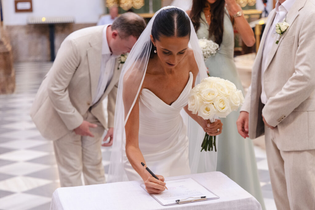 Anna signs the marriage register during the wedding ceremony at Iglesia de la Encarnación in Marbella.