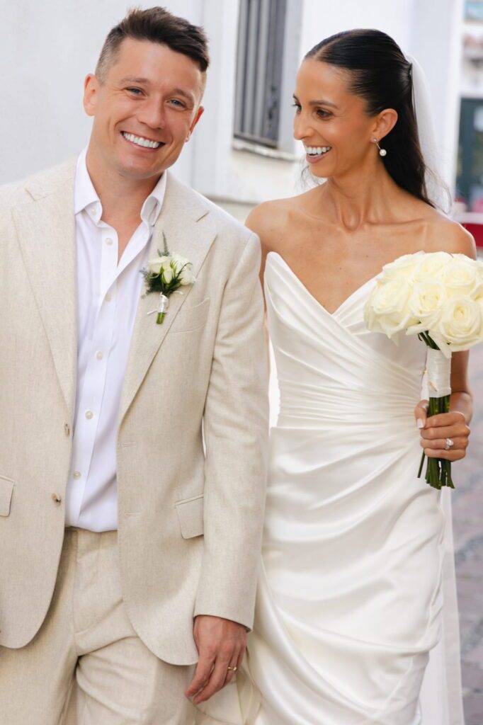 Close portrait of Michael smiling towards the camera while Anna looks at him
