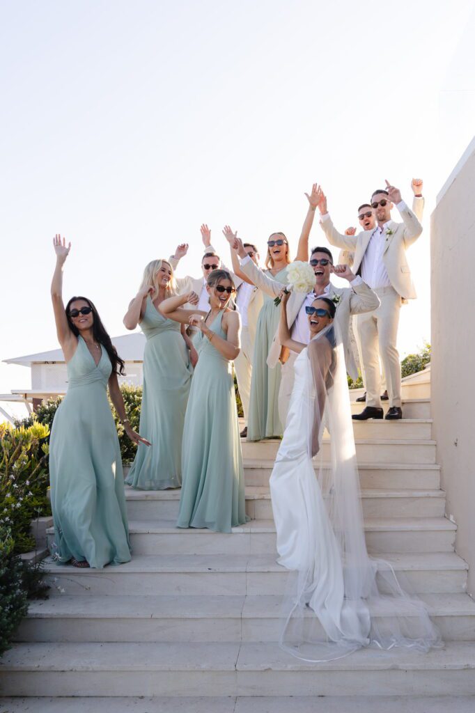 Anna and her bridesmaids cheering together on the steps of the wedding venue