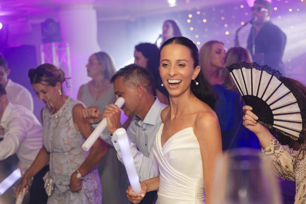 Anna smiling and dancing on the wedding dancefloor