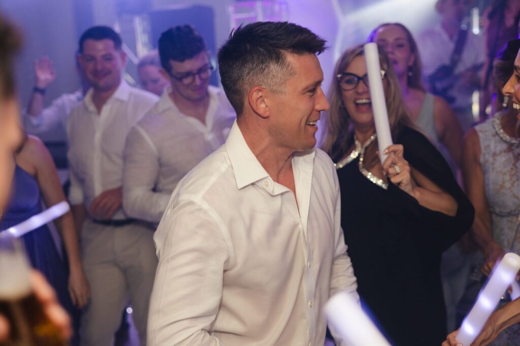 Michael smiling and dancing on the wedding dancefloor
