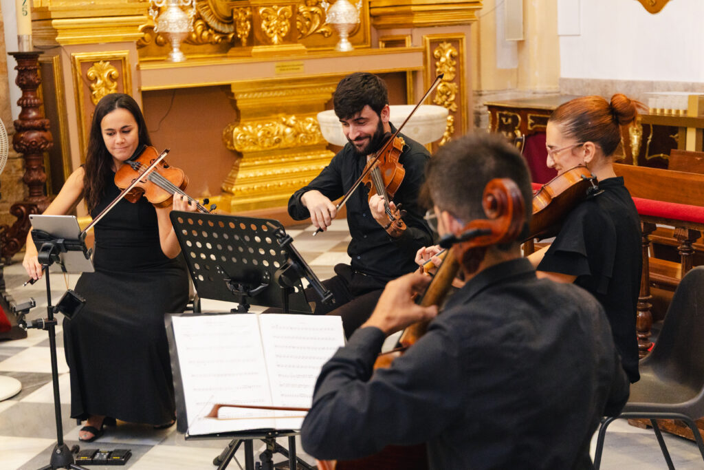 Four violinists perform during Anna and Michael's wedding ceremony at Iglesia de la Encarnación in Marbella.