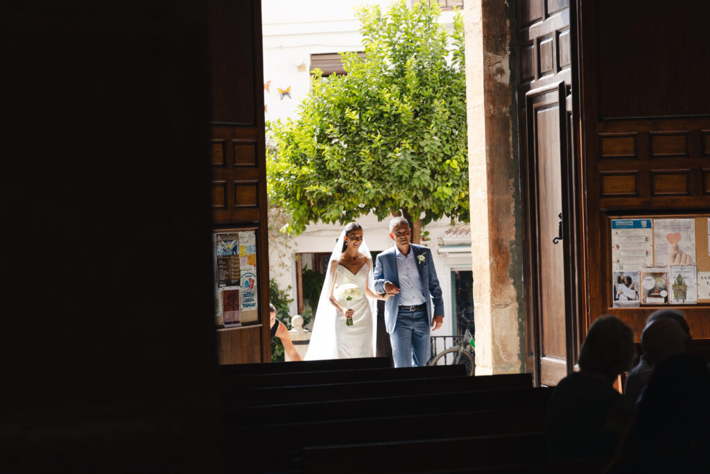Anna enters Iglesia de la Encarnación with her father for the wedding ceremony in Marbella.